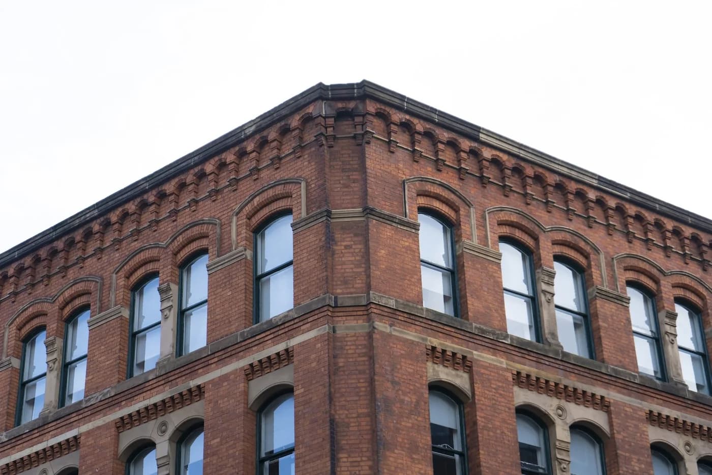 Low-angle view of a brown building beneath a cloudy sky