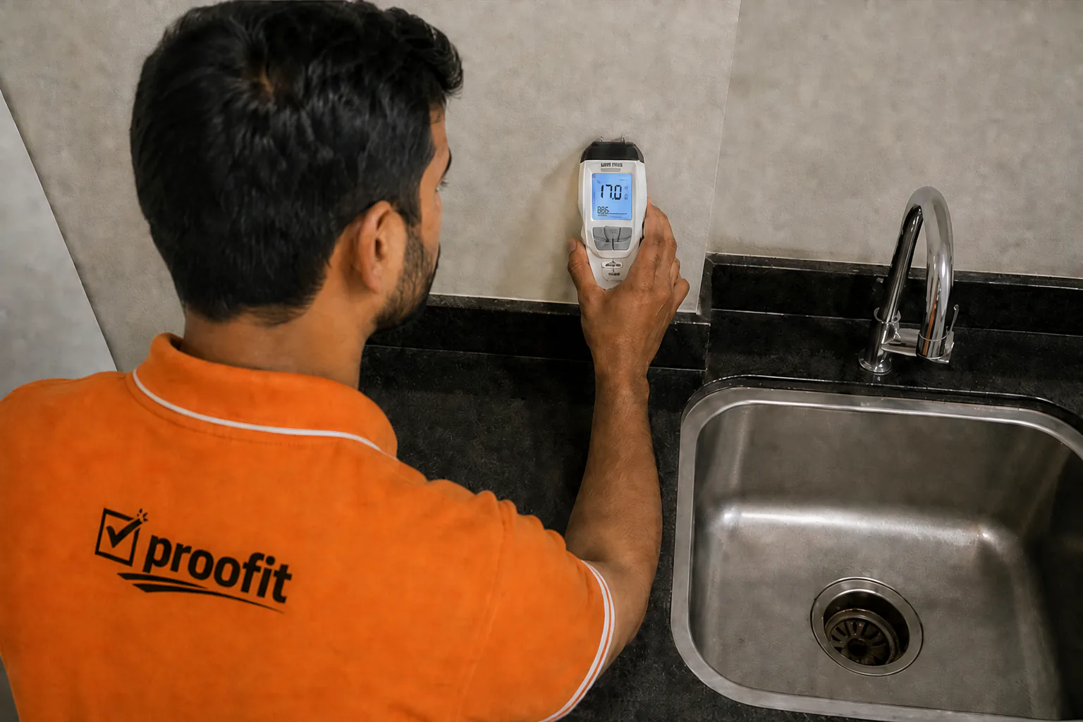 Proofit inspector checking moisture beside a kitchen sink
